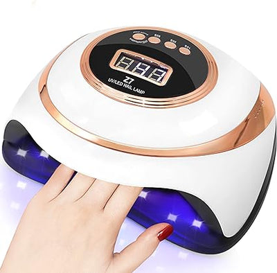 White and rose gold professional nail drying lamp with digital timer display and hand inside ultraviolet light zone.